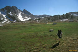 Jess walking across the meadow to Upper McCabe Lake