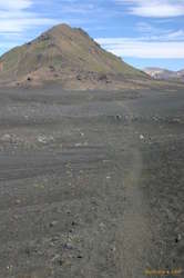 Sand, rocks, and green mountains